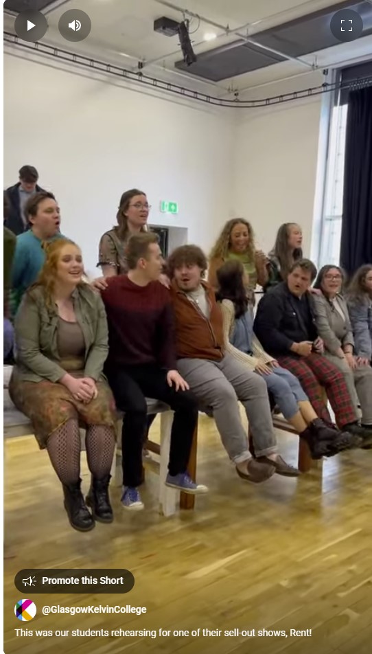 Vibrant group of Musical Theatre students rehearsing a dynamic scene from Rent at Glasgow Kelvin College.