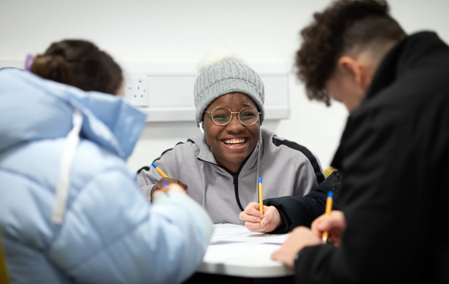 Students smiling and working together at a table in the East End campus common room at Glasgow Kelvin College. Students smiling and working together at a table in the East End campus common room at Glasgow Kelvin College.