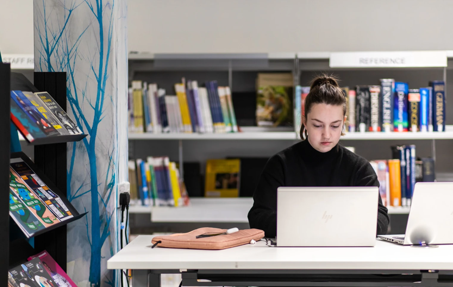 Student working on a laptop in the library at Glasgow Kelvin College’s Easterhouse campus, with bookshelves and study resources in the background. Student working on a laptop in the library at Glasgow Kelvin College’s Easterhouse campus, with bookshelves and study resources in the background.