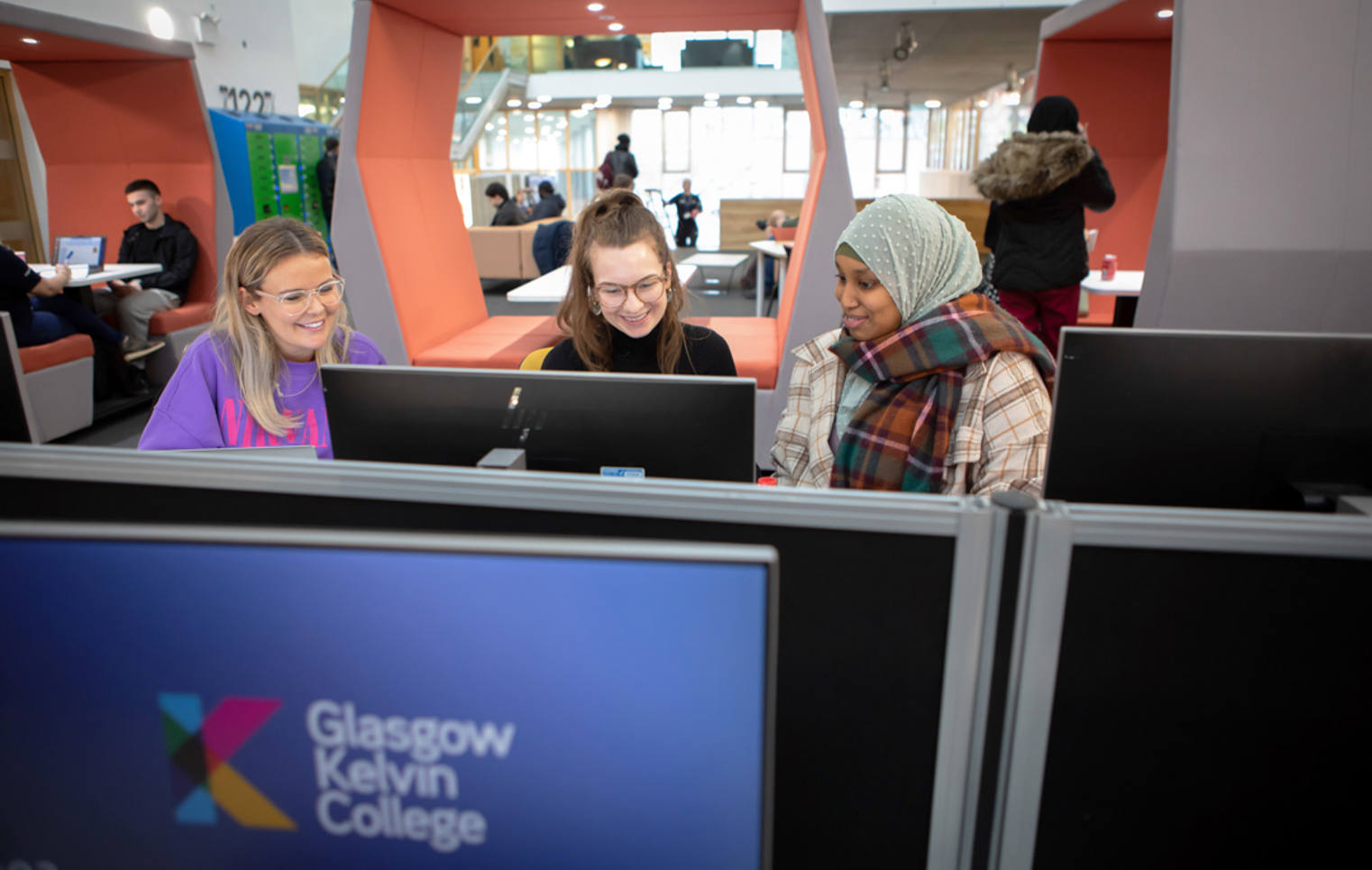 Three Smiling Students Using Computers Three Smiling Students Using Computers