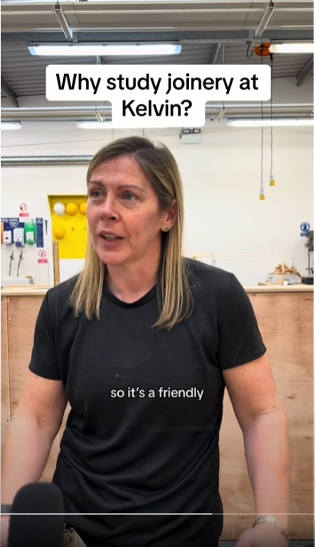 A female joinery lecturer in a black t-shirt speaking in a well-equipped workshop at Glasgow Kelvin College, with the text 'Why study joinery at Kelvin?' displayed above her.