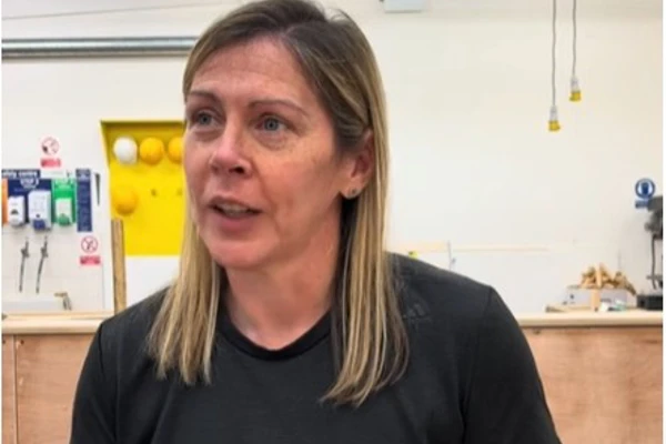A female joinery lecturer in a black t-shirt speaking in a well-equipped workshop at Glasgow Kelvin College, with the text 'Why study joinery at Kelvin?' displayed above her. A female joinery lecturer in a black t-shirt speaking in a well-equipped workshop at Glasgow Kelvin College, with the text 'Why study joinery at Kelvin?' displayed above her.