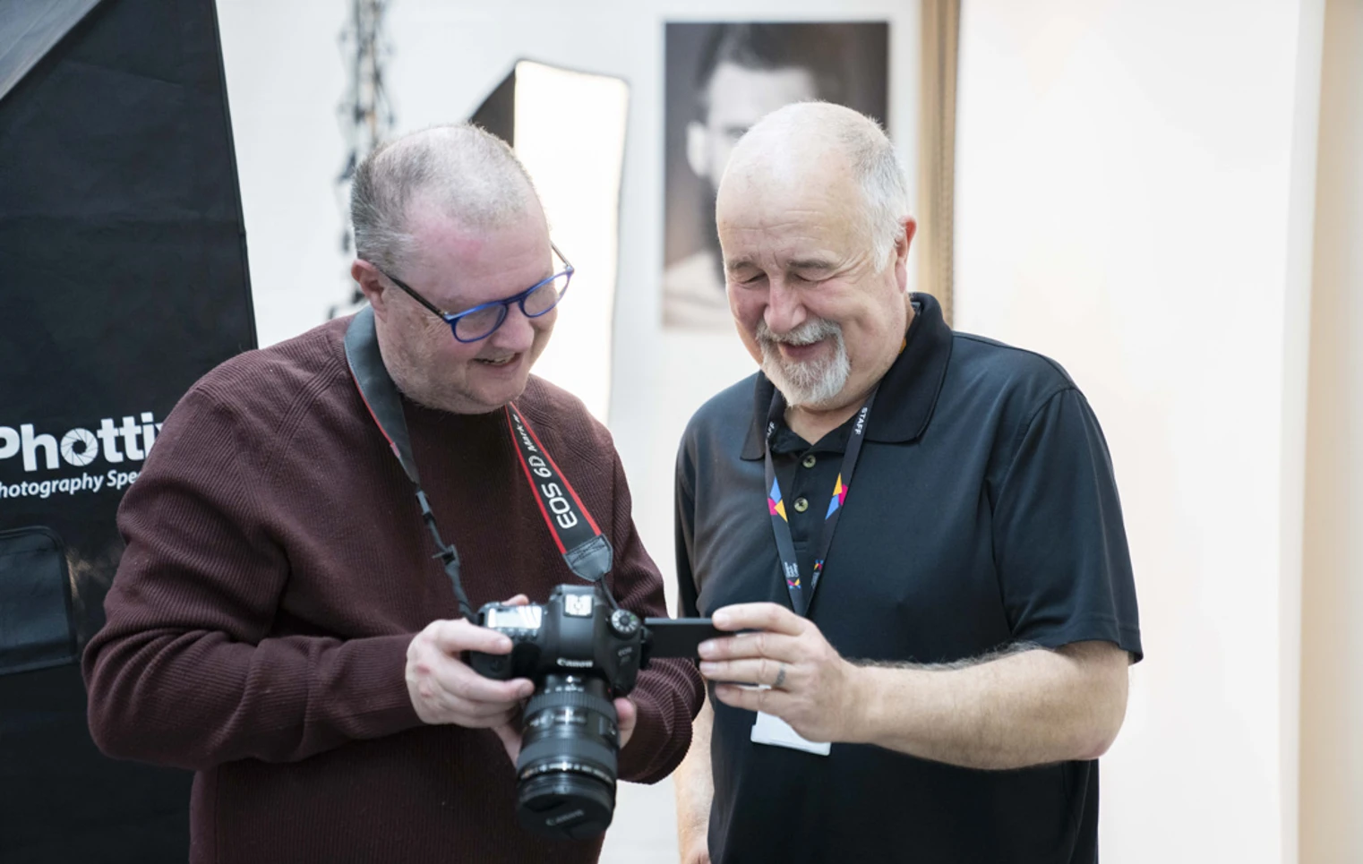 Two older students reviewing a photo on a DSLR camera screen in a professional studio setting. Two older students reviewing a photo on a DSLR camera screen in a professional studio setting.