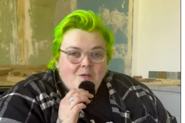 A Photography student at Glasgow Kelvin College with bright green hair and tattoos speaks into a microphone, discussing architecture photography during an interview. A Photography student at Glasgow Kelvin College with bright green hair and tattoos speaks into a microphone, discussing architecture photography during an interview.
