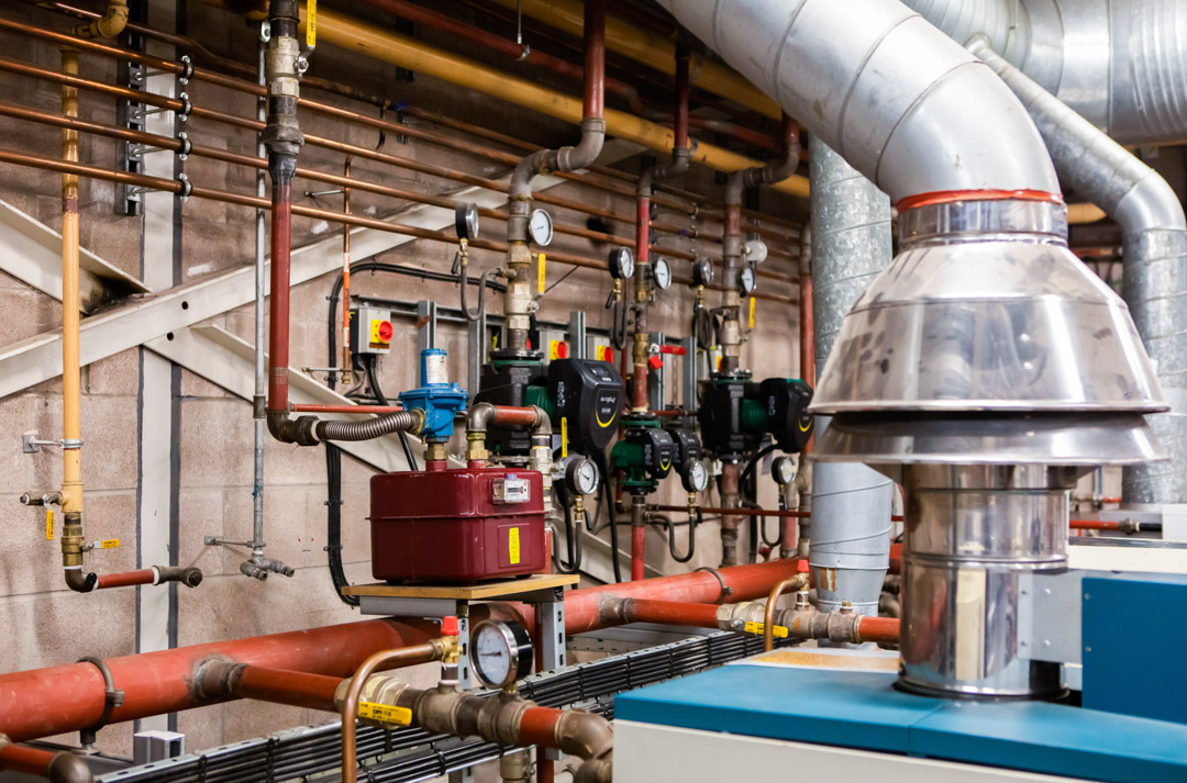 Building services training equipment including pipes, valves and heating systems in a college workshop.