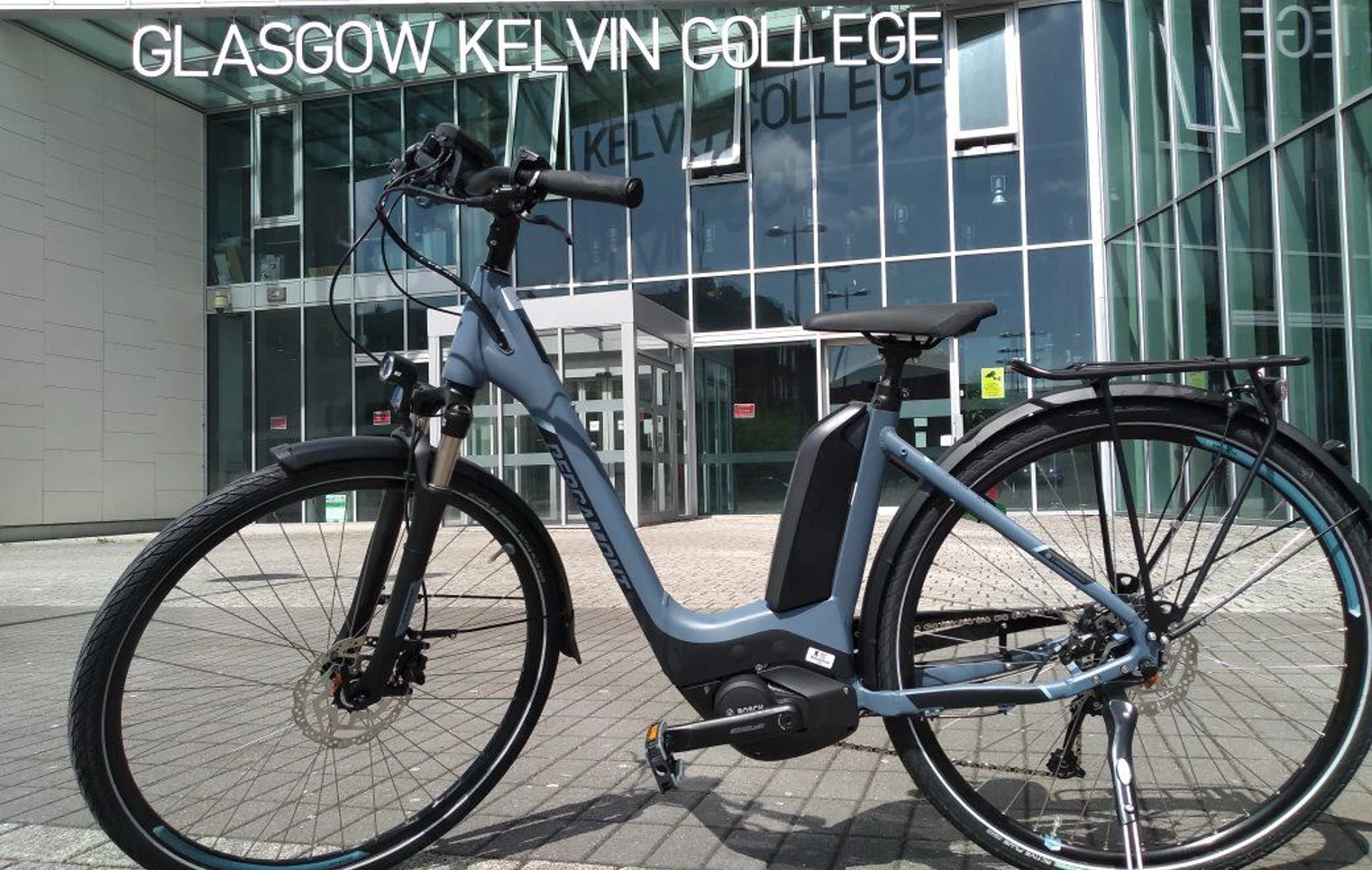 Electric bike parked outside the glass entrance of Glasgow Kelvin College Springburn campus. Electric bike parked outside the glass entrance of Glasgow Kelvin College Springburn campus.