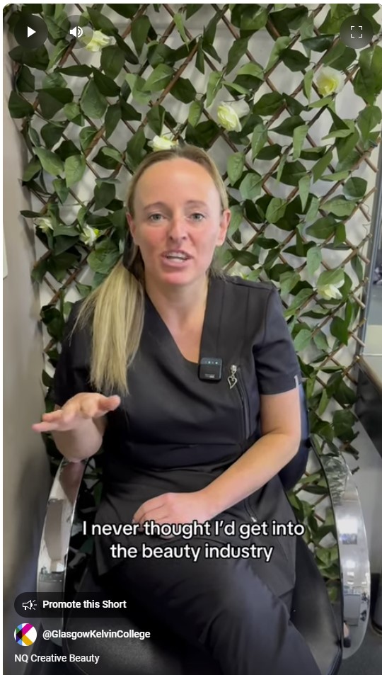 A beauty student in a black uniform sharing their journey into the beauty industry, seated in front of a green floral backdrop.