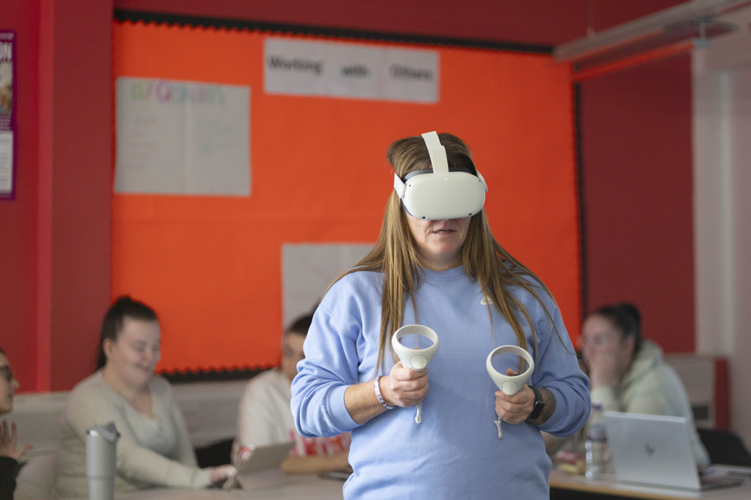 Student using a virtual reality headset and hand controllers during a learning activity at Glasgow Kelvin College.